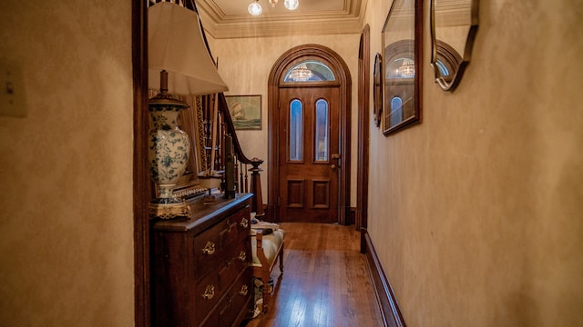 doorway with dark hardwood / wood-style flooring and crown molding