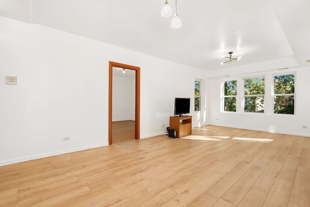 unfurnished living room featuring light hardwood / wood-style floors and a chandelier