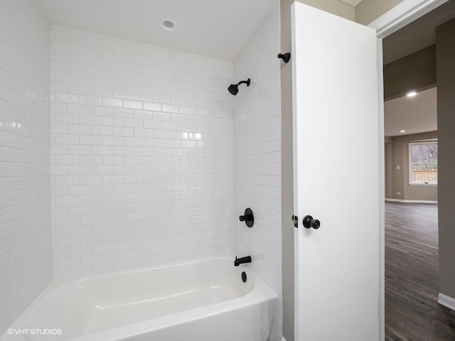 bathroom featuring tiled shower / bath combo and wood-type flooring