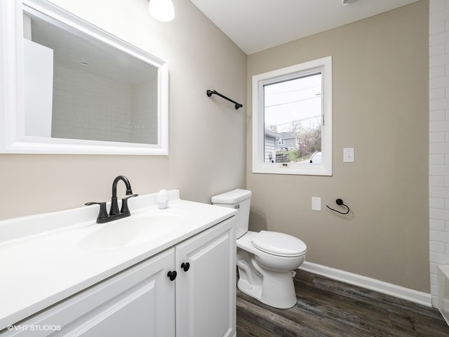 bathroom with a shower, vanity, wood-type flooring, and toilet