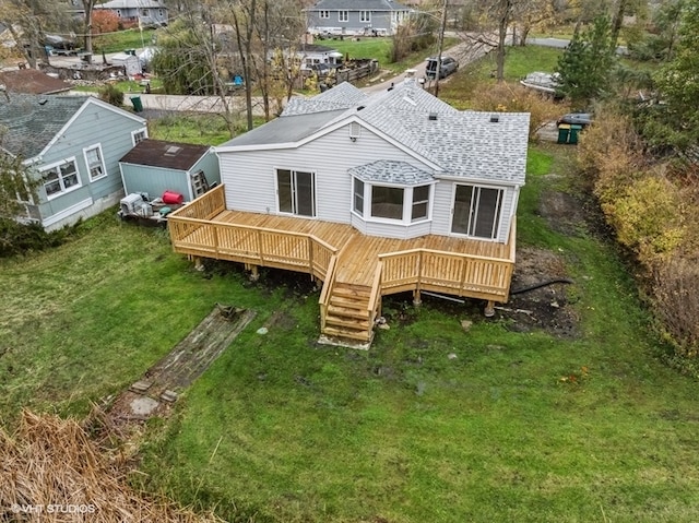 back of property featuring a lawn and a deck