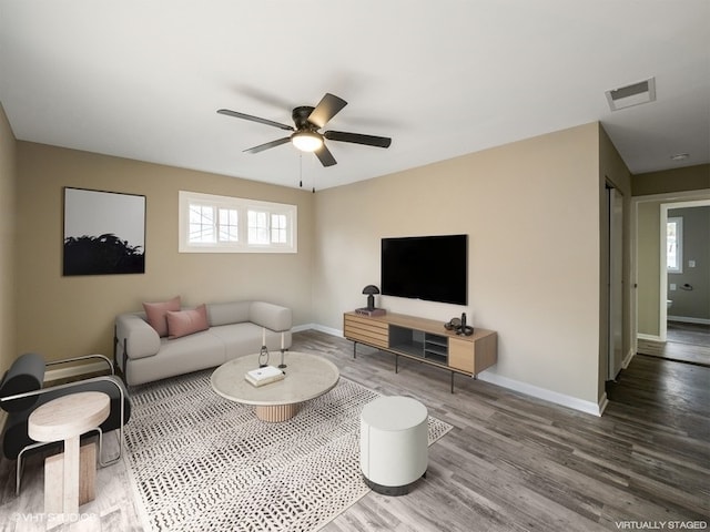 living room with a wealth of natural light, hardwood / wood-style floors, and ceiling fan