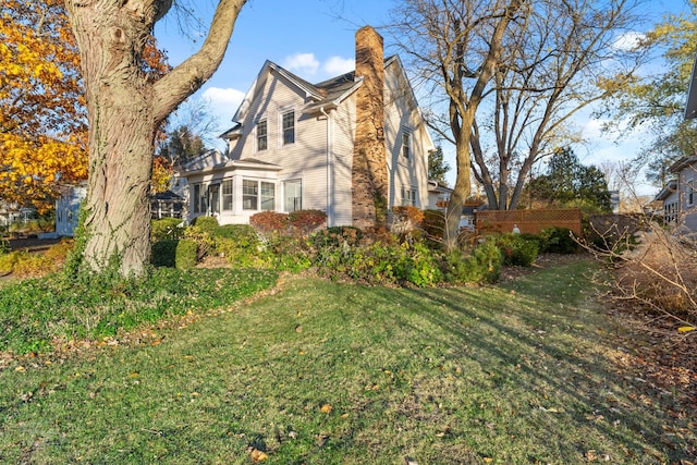 view of side of home with a yard and a sunroom