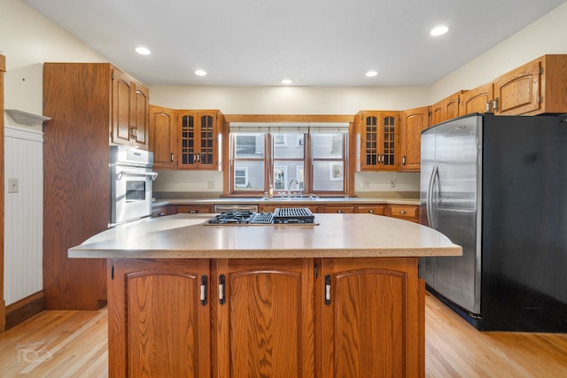 kitchen featuring a kitchen island, sink, light wood-type flooring, and stainless steel appliances