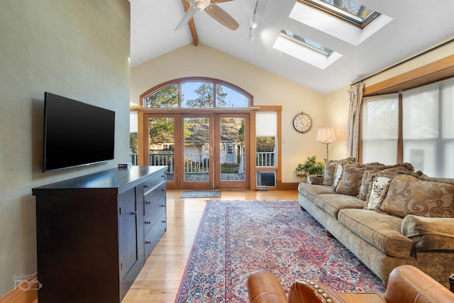 living room with rail lighting, ceiling fan, high vaulted ceiling, and light wood-type flooring