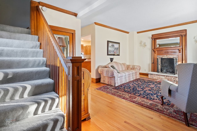 living room featuring hardwood / wood-style floors, a brick fireplace, and crown molding