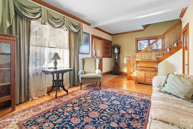 living room featuring light hardwood / wood-style floors, crown molding, and beam ceiling