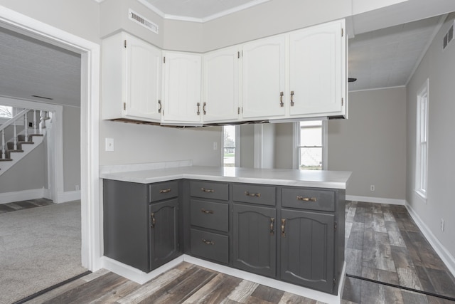 kitchen featuring kitchen peninsula, dark hardwood / wood-style flooring, gray cabinets, and white cabinetry