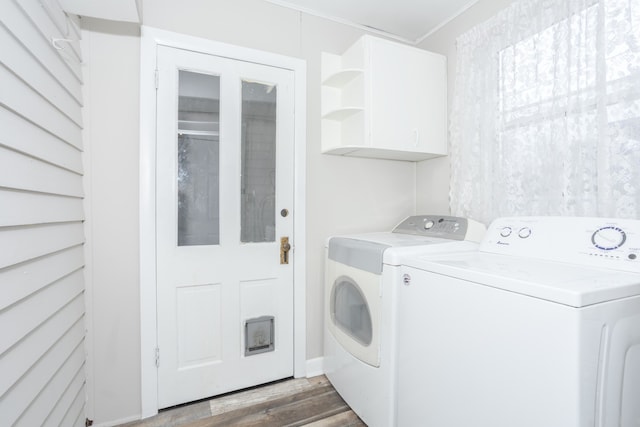 clothes washing area featuring cabinets, independent washer and dryer, ornamental molding, and dark wood-type flooring