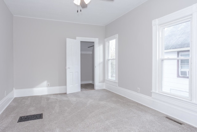 empty room featuring ceiling fan and carpet