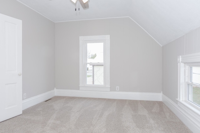 additional living space featuring light carpet, ceiling fan, and vaulted ceiling