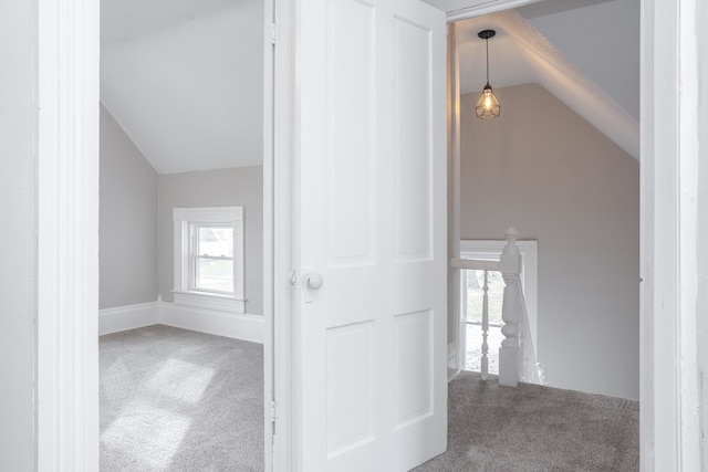 corridor featuring carpet and vaulted ceiling