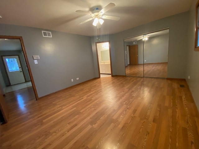 unfurnished bedroom with ceiling fan, a closet, and wood-type flooring