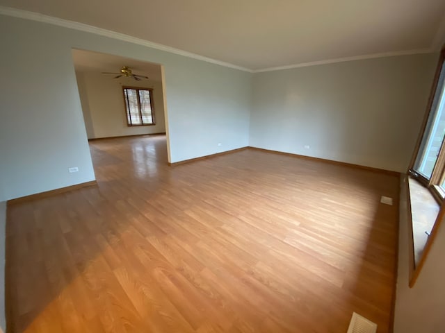 spare room with light wood-type flooring, ceiling fan, and crown molding