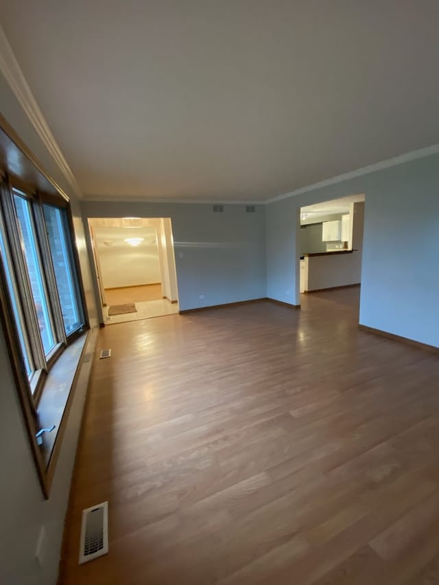 empty room featuring hardwood / wood-style floors and ornamental molding