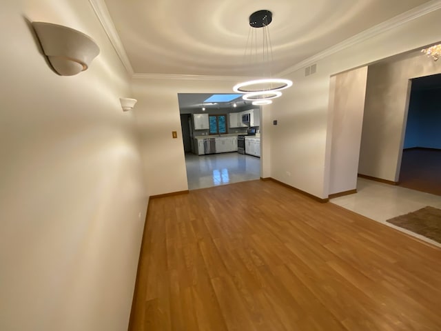 interior space featuring wood-type flooring, an inviting chandelier, and crown molding