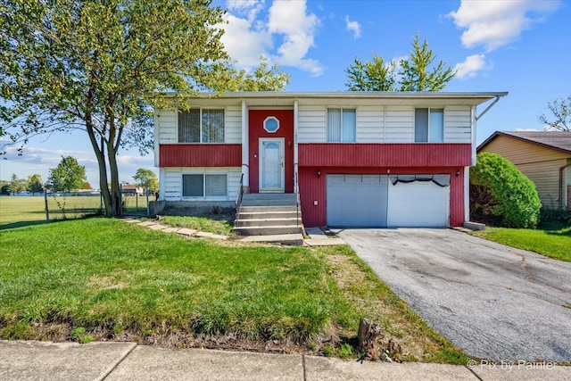 raised ranch with a front lawn and a garage