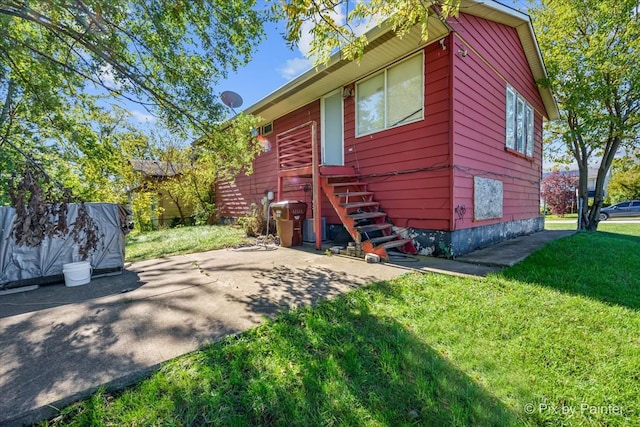 rear view of property featuring a lawn and a patio