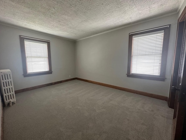 carpeted empty room with radiator heating unit, a textured ceiling, and ornamental molding