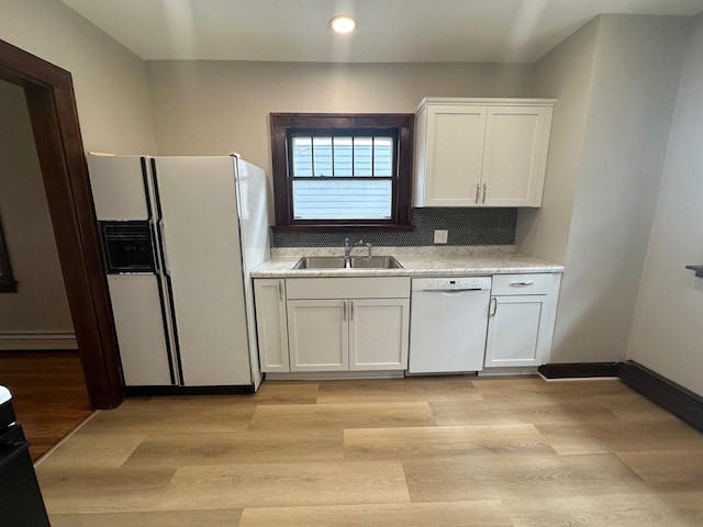 kitchen featuring white cabinets, light wood-type flooring, white appliances, and sink