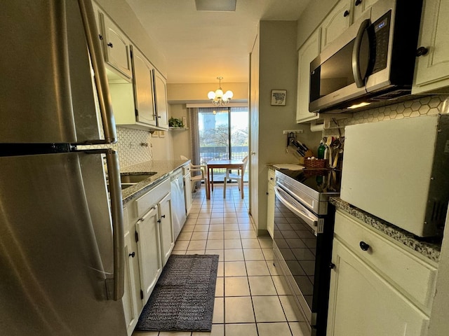 kitchen featuring stainless steel appliances, white cabinetry, hanging light fixtures, and light tile patterned floors