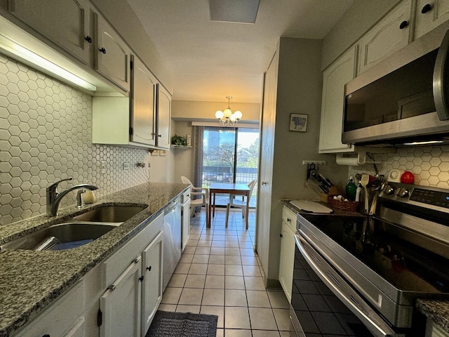 kitchen with pendant lighting, sink, appliances with stainless steel finishes, a notable chandelier, and white cabinets