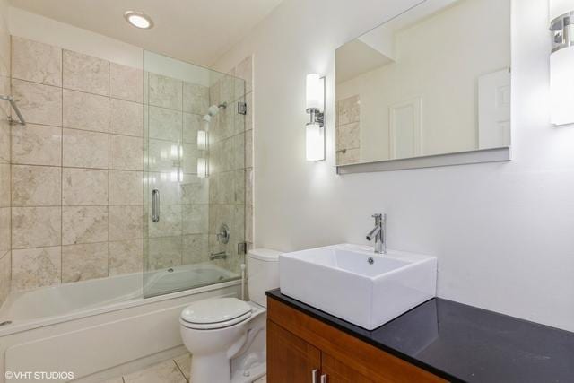 full bathroom with tiled shower / bath combo, toilet, and vanity