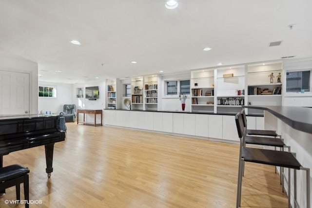 kitchen featuring built in features, light hardwood / wood-style floors, and white cabinetry