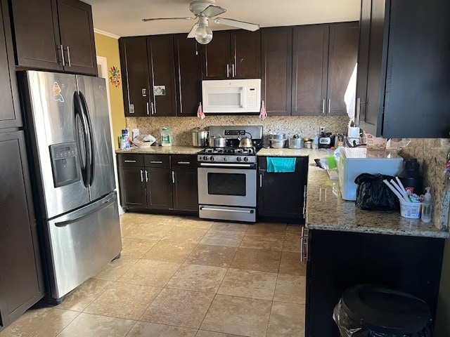 kitchen featuring stainless steel appliances, dark brown cabinets, ceiling fan, and backsplash