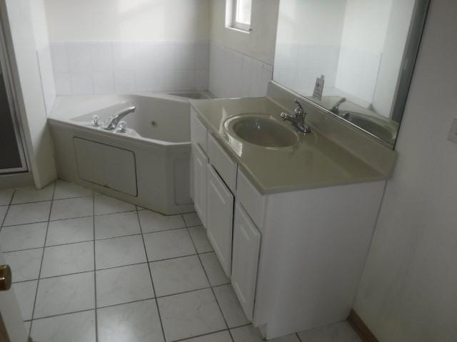 bathroom with tile patterned floors, a bathing tub, and vanity