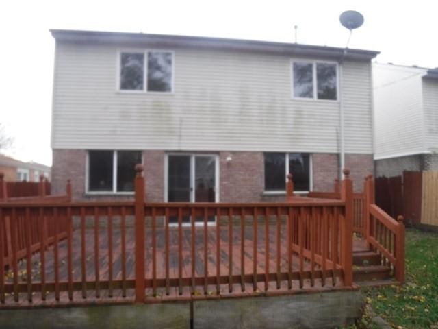 rear view of house featuring a wooden deck