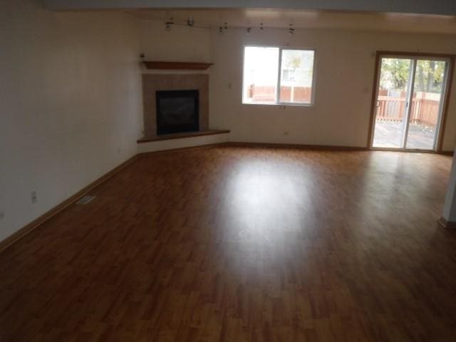 unfurnished living room with hardwood / wood-style flooring and plenty of natural light