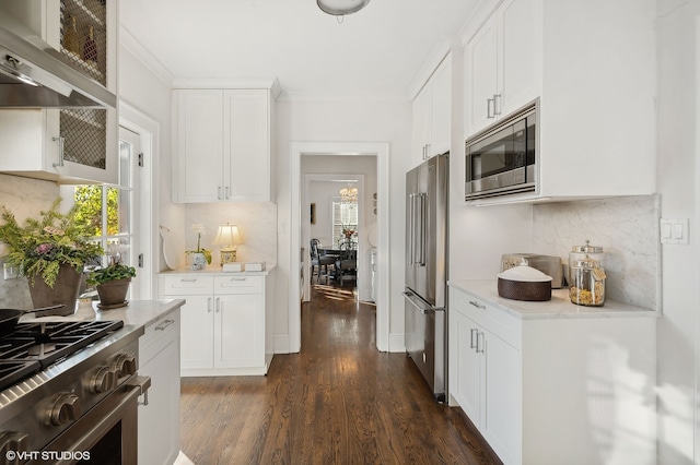 kitchen with white cabinetry, high quality appliances, dark hardwood / wood-style flooring, and wall chimney range hood