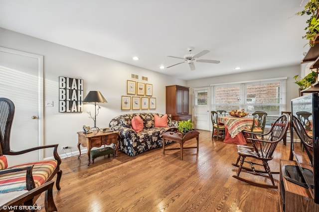 living room featuring ceiling fan and light hardwood / wood-style flooring