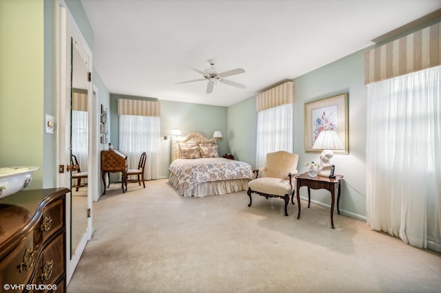 carpeted bedroom with ceiling fan and multiple windows