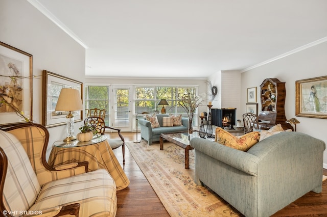 living room with a large fireplace, wood-type flooring, and crown molding