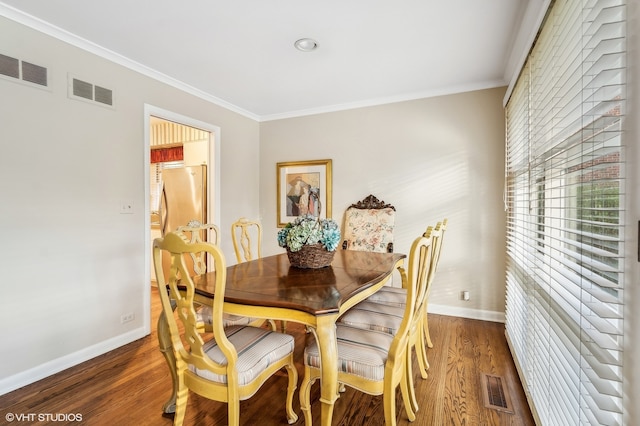 dining area featuring ornamental molding and dark wood-type flooring