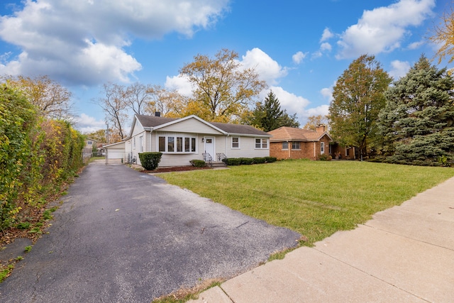 single story home featuring an outbuilding, a front lawn, and a garage