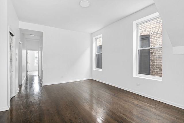 unfurnished room with dark wood-type flooring