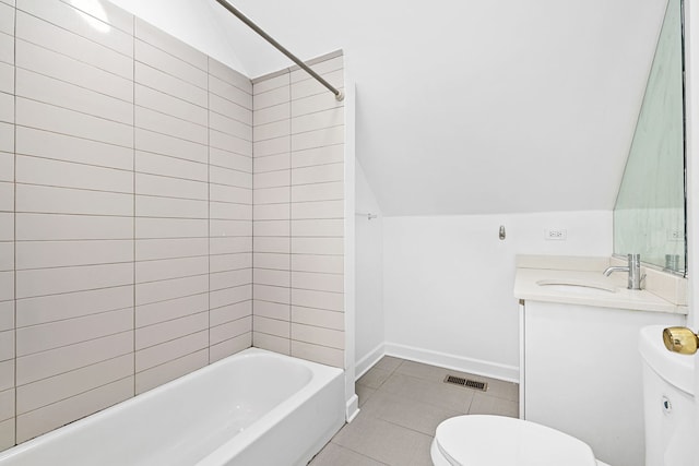 full bathroom with vanity, vaulted ceiling, tile patterned flooring, toilet, and tiled shower / bath