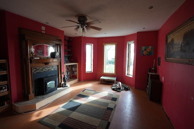 living room featuring ceiling fan and a wood stove