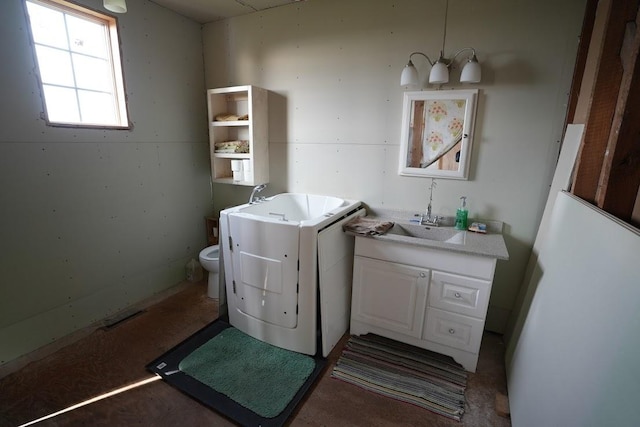 bathroom featuring toilet, vanity, and washer / dryer