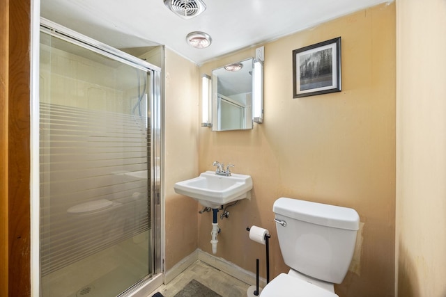 bathroom with walk in shower, sink, and toilet