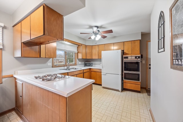 kitchen featuring kitchen peninsula, white appliances, ceiling fan, and sink