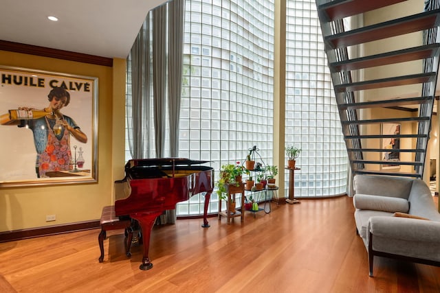 living area featuring wood-type flooring and crown molding