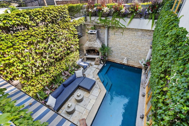 view of pool with a stone fireplace and a patio area