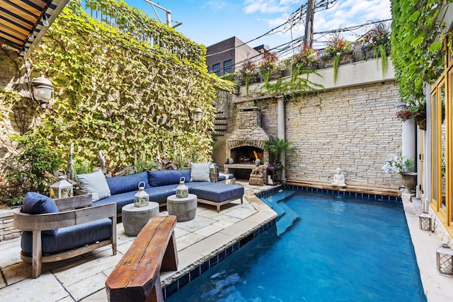 view of swimming pool with an outdoor living space with a fireplace and a patio area