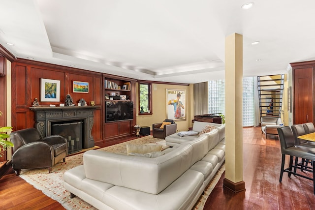 living room with hardwood / wood-style flooring and a tray ceiling