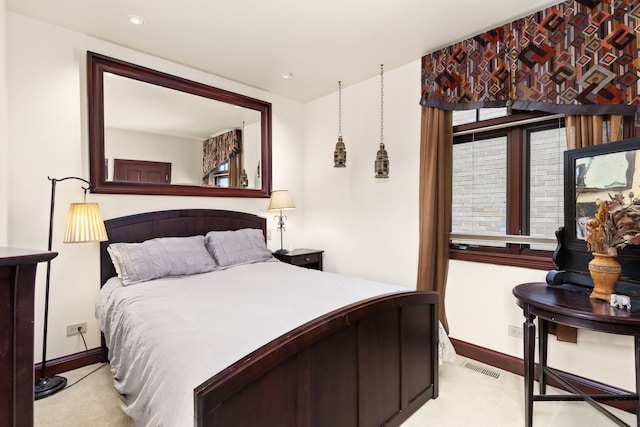 bedroom featuring light colored carpet and multiple windows