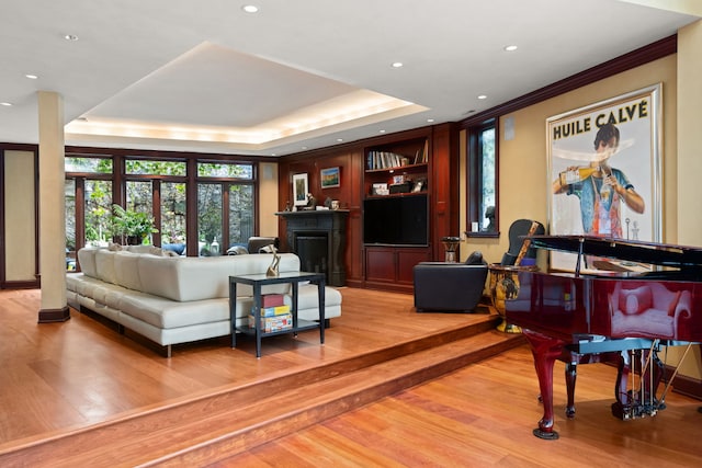 living room with light hardwood / wood-style flooring and a tray ceiling